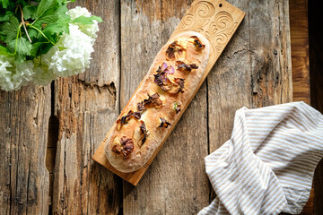 Homemade loaf decorated with edible flowers. Sourdough loaf.