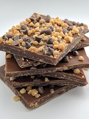 Stacked chocolate toffee bark on white background