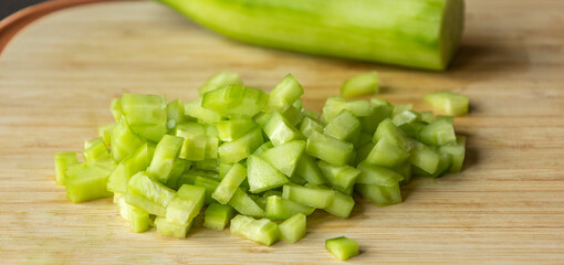  chop fresh cucumber on a wooden cutting board close-up