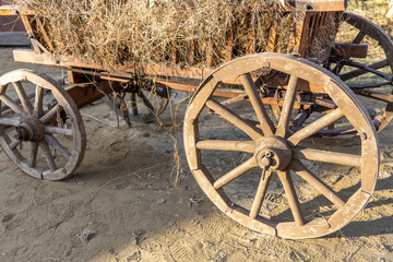 Fototapeta premium Wooden wagon wheel with straw on it