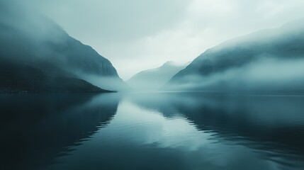 Fototapeta premium Serene misty lake and mountains reflecting in calm waters