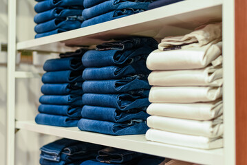 assortment of denim cotton jeans on the shelves of Tommy Hilfiger store