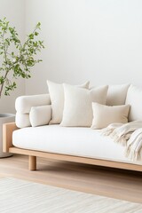 Sleek modern sofa adorned with soft pillows rests in a bright, airy space featuring greenery and warm wooden accents, creating a tranquil atmosphere