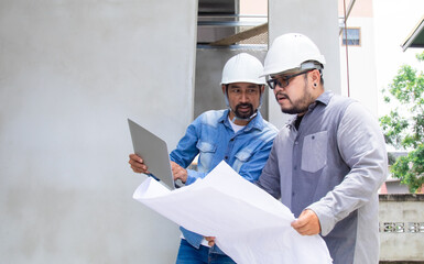 Team of Asian foremen, or head engineers construction supervisors wearing white helmet hold blueprints inspect building in workplace site, Professional supervisors discuss or solving problem concept