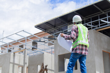 Asian or Indian contractor man engineer wearing a white hard hat and reflective safety vest stands...
