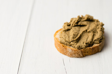 Healthy food, delicious beef liver pate on a baguette with a crispy crust on a light table