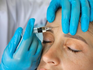 Client receiving cosmetic injection for wrinkle reduction at a beauty clinic during a treatment...