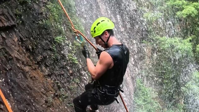 homem mochileiro faz rapel em cachoeira 