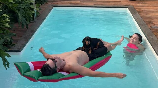 homem relaxa na piscina com cachorro fofo e filha 