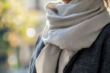 Fototapeta premium Soft scarf layered over tailored jacket in minimalist setting