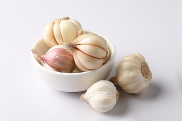 Garlic  Bulb in a ceramic bowl.Garlic is a common cooking ingredient with health benefits. Examples include managing cholesterol, boosting heart health, supporting the immune system, protectin
