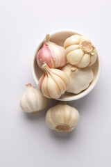 Garlic  Bulb in a ceramic bowl.Garlic is a common cooking ingredient with health benefits. Examples include managing cholesterol, boosting heart health, supporting the immune system, protectin