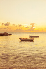 Obraz premium Two small fishing boats in sunset at the Caribbean Sea