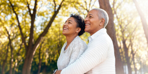 Naklejka premium Retired couple outside in a park on a sunny day laughing and having fun together in their golden years
