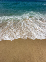 blue ocean and white waves on a sandy beach
