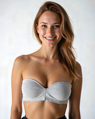 Obraz premium Young Caucasian woman wearing a stylish gray bandeau top, exuding confidence and charm in a captivating portrait shot