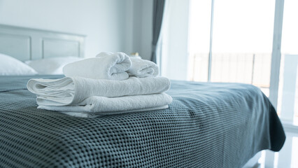 Close-up of white towel folded on the bed, in bedroom for rest and relax, feel comfortable concept