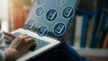 Person working on laptop with document icons overlay, library setting