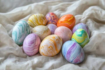 Obraz premium Collection of colorful marble patterned Easter eggs resting on a soft, textured fabric, showcasing intricate designs and vibrant hues
