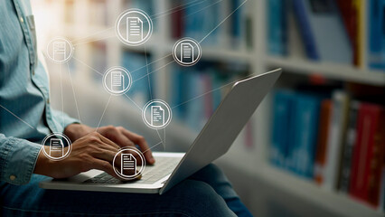 Person working on laptop with document icons overlay, library setting