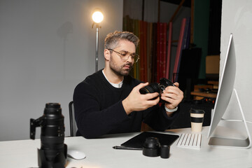 Creative professional reviewing camera settings in a modern workspace filled with equipment