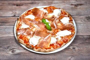 Pizza margherita with buffalo mozzarella and Parma ham isolated on wooden background
