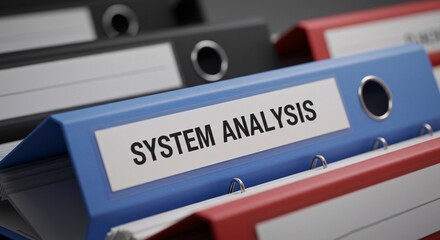 a blue binder with a white label reading "SYSTEM ANALYSIS" in black text. The background is blurred, showing folders in black, gray, and red. The image suggests business, IT, or data analysis.