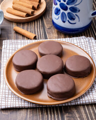Brazilian Pao de Mel or chocolate covered honey cookies over a wooden table