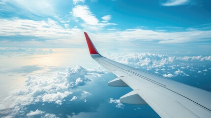 Obraz premium The tail of an airplane visible high above the ocean, with only a few scattered clouds below, symbolizing the vastness of transatlantic flight.