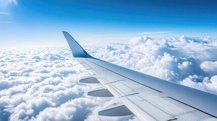 Obraz premium The wing of an airplane gliding through the sky above a sea of clouds, evoking the feeling of freedom and distance in international travel.