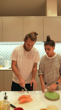 A couple enjoys the delightful experience of cooking together in their stylish modern kitchen