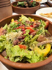 Salad in a clay bowl. Georgian salad in cafe. Vertical