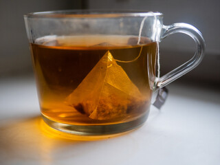 Glass Cup with Pyramid Tea Bag in Warm Light