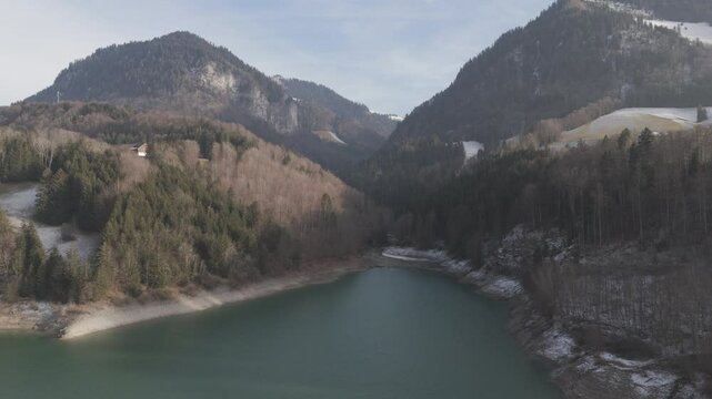 Margem de um lago verde com duas diferentes esta&ccedil;&otilde;es uma verdejante e com gelo ou neve e outra seca e des&eacute;rtica 