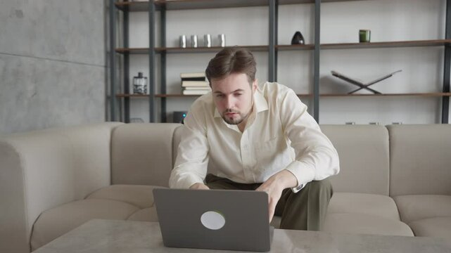 Focused Businessman Leaning Forward Working Intensely On Laptop In Modern Office