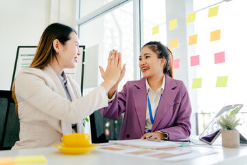 Two women are holding hands in a business atmosphere. coworkers holding hands Successful agreement after excellent meeting The scene is professional and friendly.