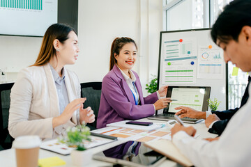 Obraz premium Three people are sitting at a table with a white board behind them