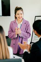 Woman in a purple jacket is giving a presentation to a group of people