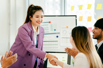 Fototapeta premium Woman shakes hands with another woman in a purple jacket
