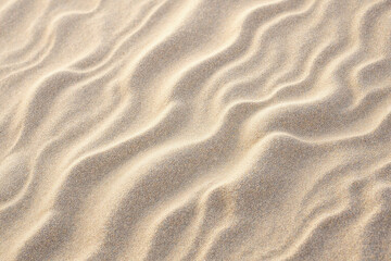 Fototapeta premium Wavy sand texture, warm beige tones, representing tranquility or relaxation, with copy space