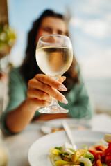 Close up of woman's hand hold glass with white wine 
