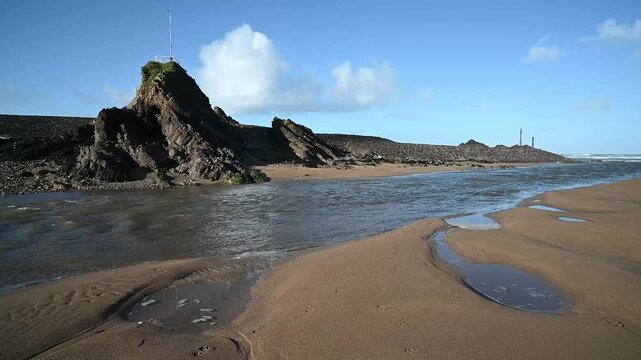 Rocks sand and flowing warer on Bude beach Cornwall