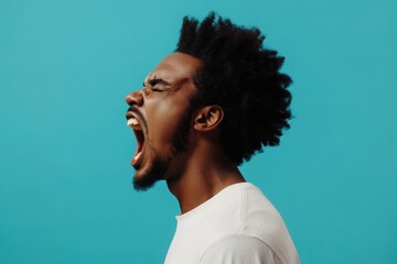 Obraz premium Young afro man shouting. Crying emotional man screaming on blue studio background. Male half-length profile portrait. Human emotions, facial expression concept. Trendy colors