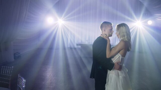Newlyweds sharing a romantic moment, dancing their first dance together as husband and wife in a beautifully lit reception hall