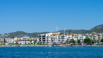 View from Mediterranean Sea to embankment of city Marmaris, Turkey. Ship moored at pier