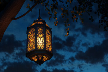 A beautifully lit traditional Ramadan lantern glowing in the night sky