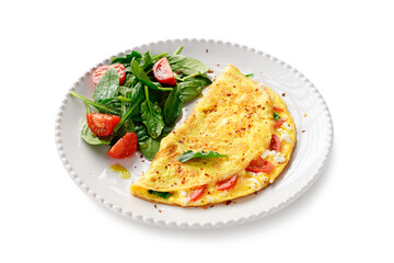 Stuffed omelette with tomatoes and ricotta cheese, served with fresh spinach leaves and cherry tomatoes. Healthy breakfast. Isolated on white background