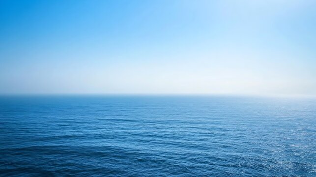 The vast blue ocean water meets a clear cloudless sky