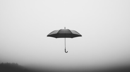 A lonely open umbrella suspended in a monochrome foggy environment