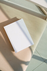blank book mockup on soft armchair on terrace or balcony outdoor, shadow overlay